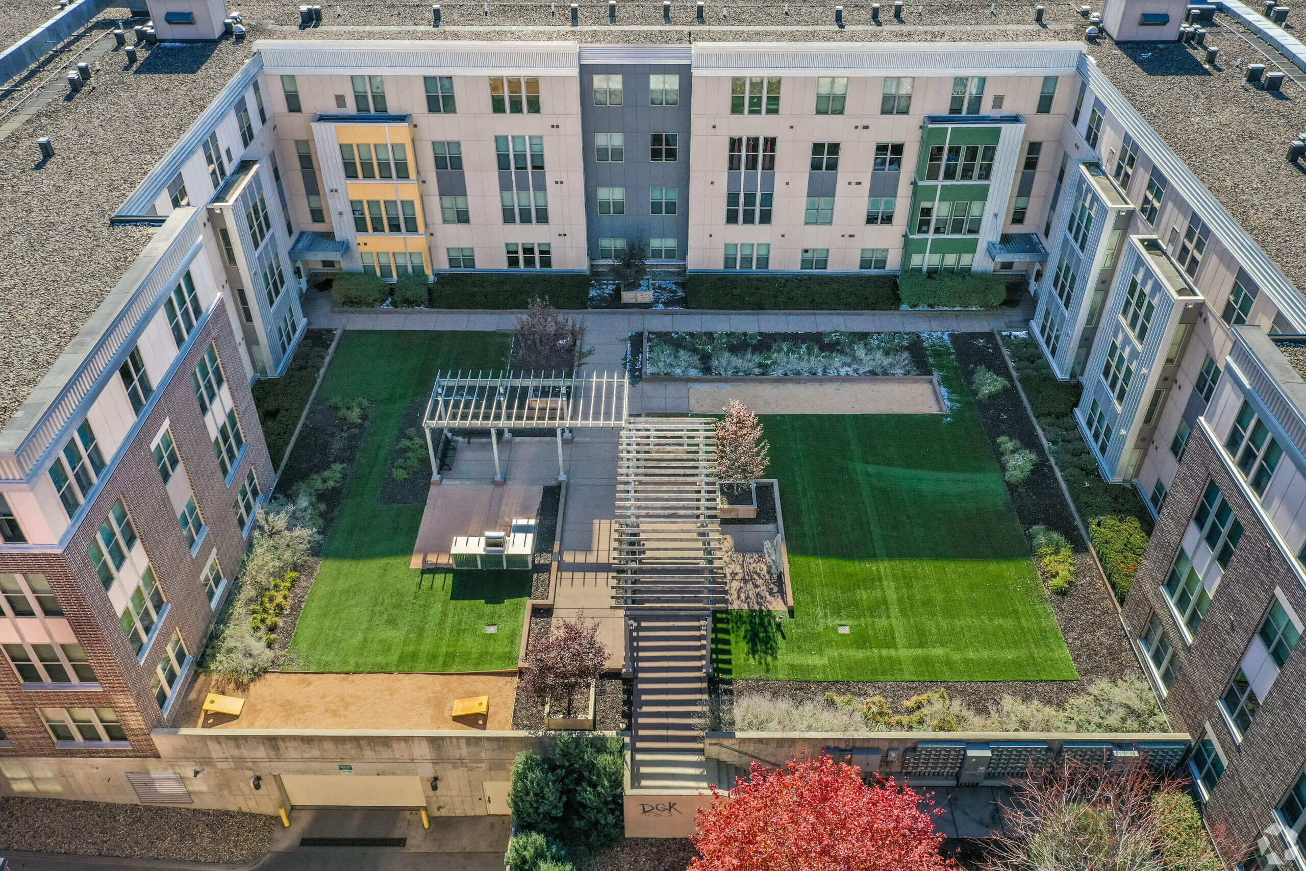 Metro Lofts apartment building exterior courtyard with grass and seating area.