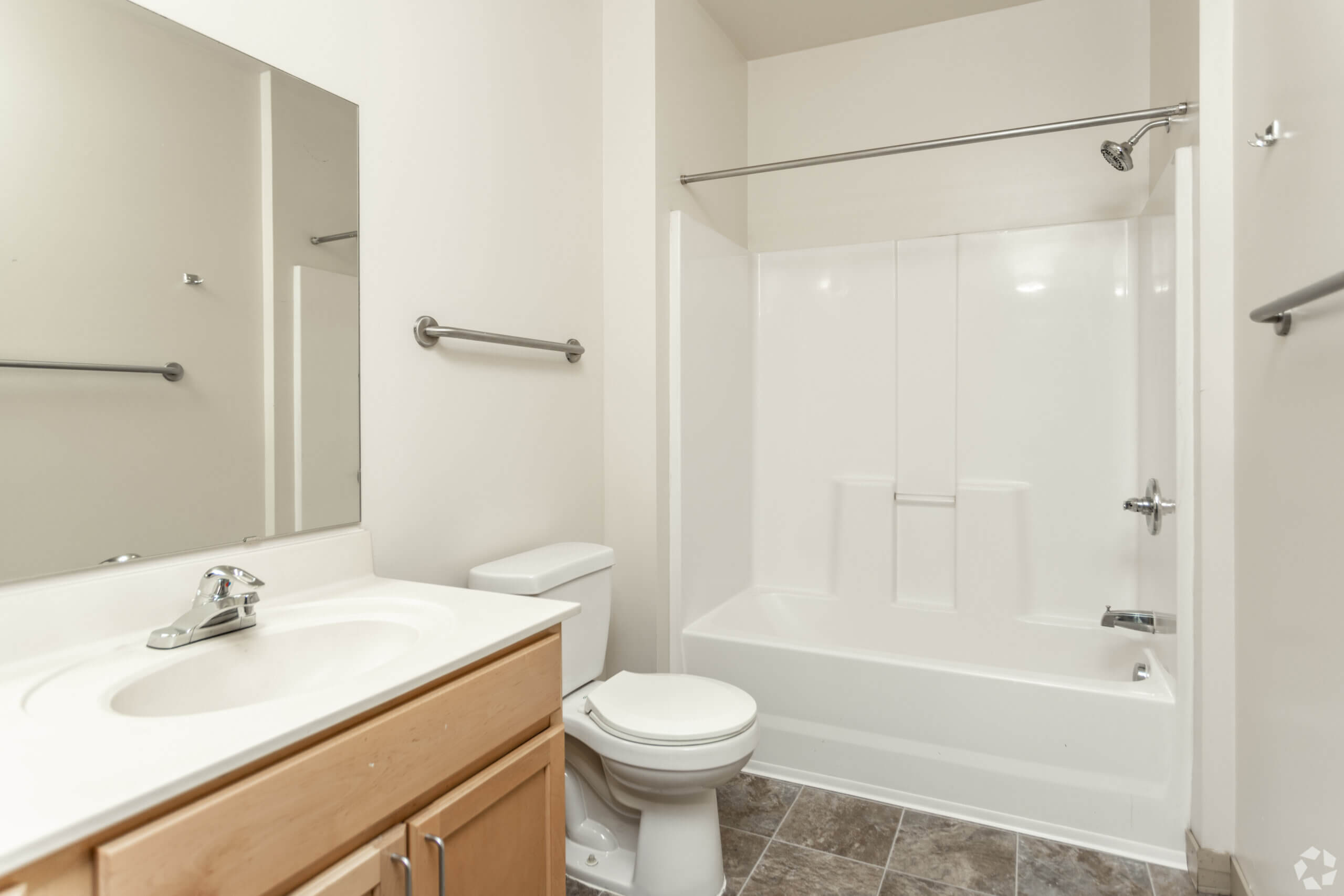 Metro Lofts Apartments interior bathroom. White bathtub and vanity with a mirror.
