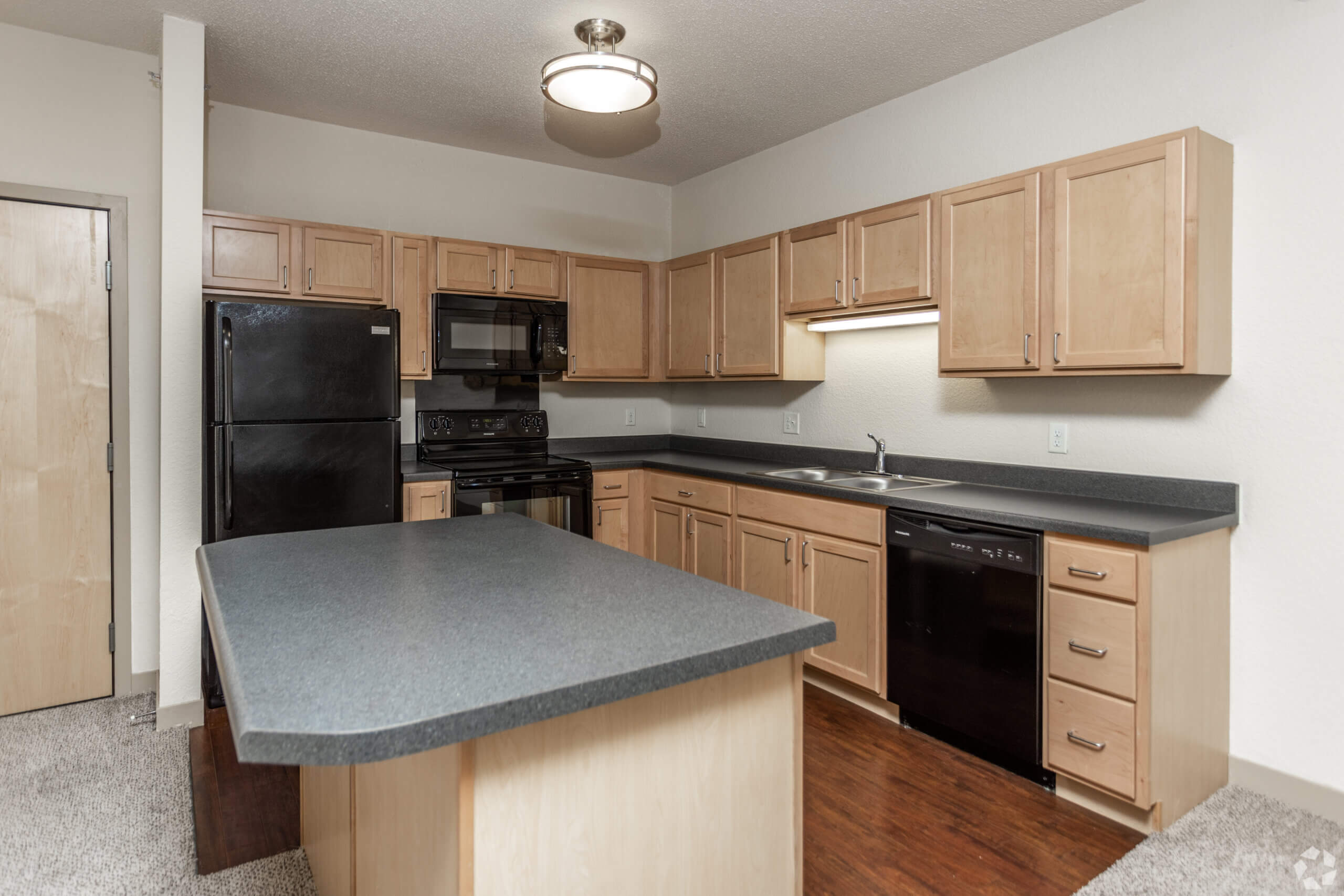 Metro Lofts Apartments interior kitchen image. Neutral walls and plush carpet.