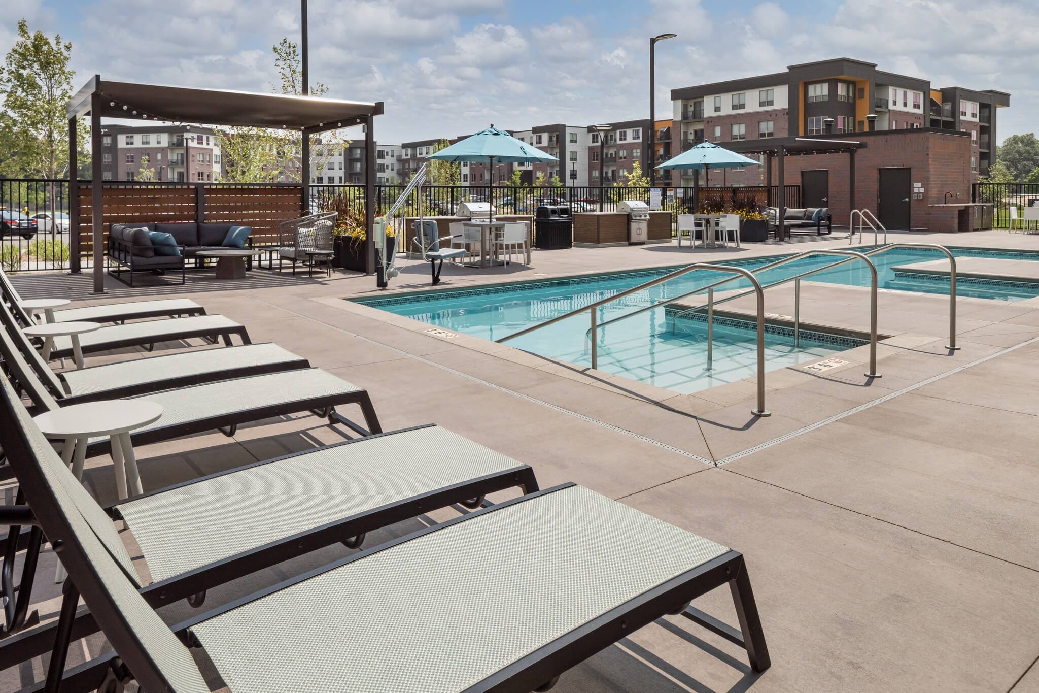 Aster at Riverdale Station pool showing lounge seating and umbrellas