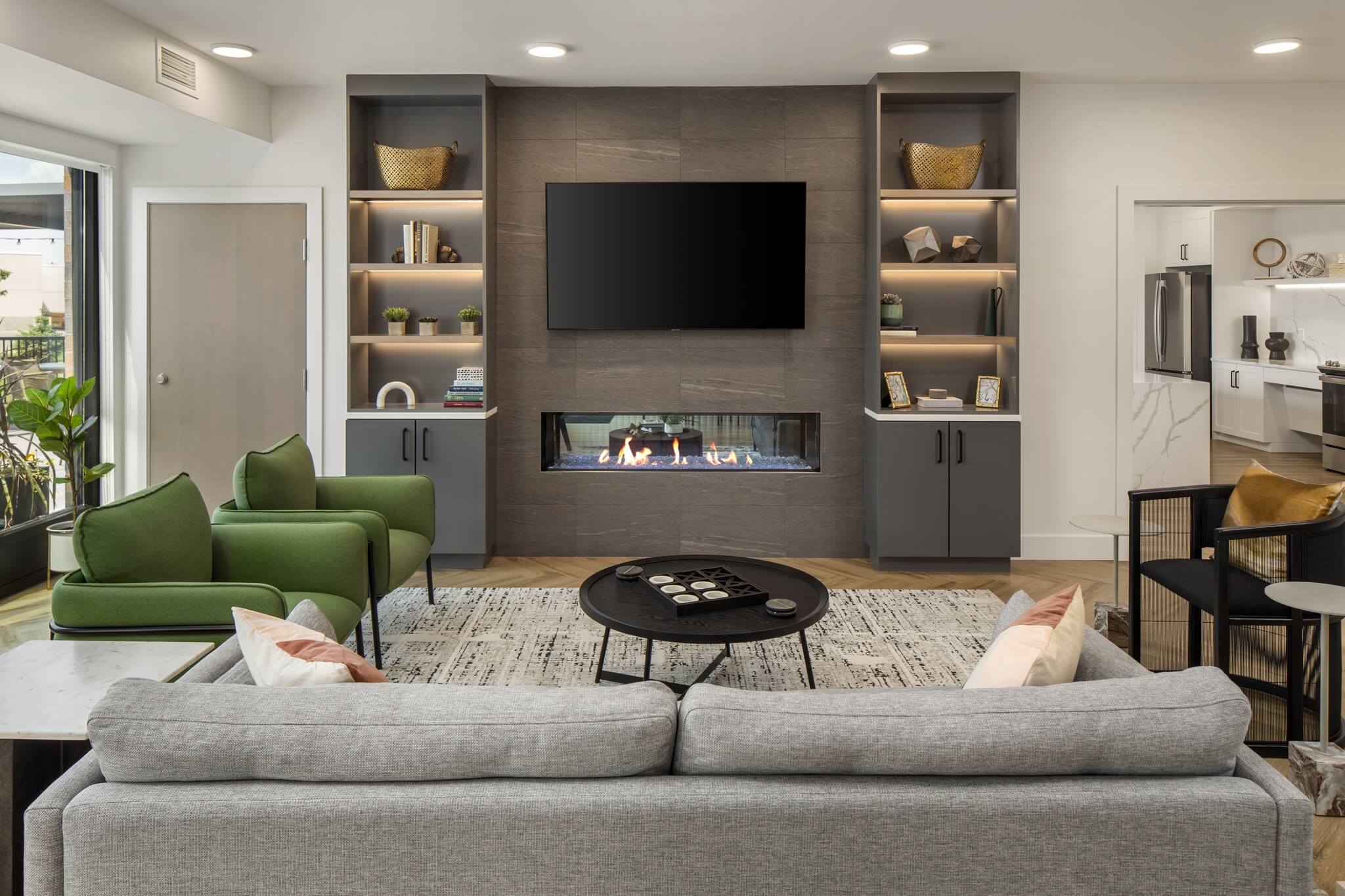 Aster at Riverdale Station amenity lounge with fireplace, large TV, and large couch